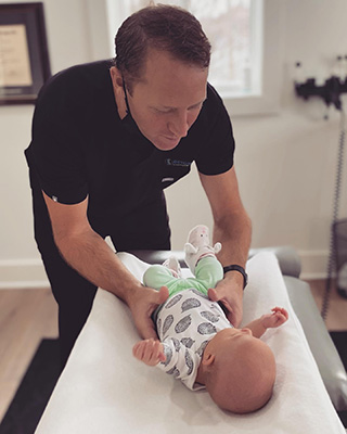 Chiropractor Cutlerville MI Aaron DeYoung With Baby